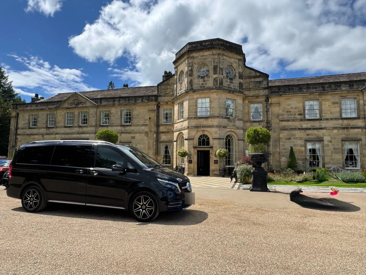 Black Mercedes V-Class chauffeur car outside a country-house hotel