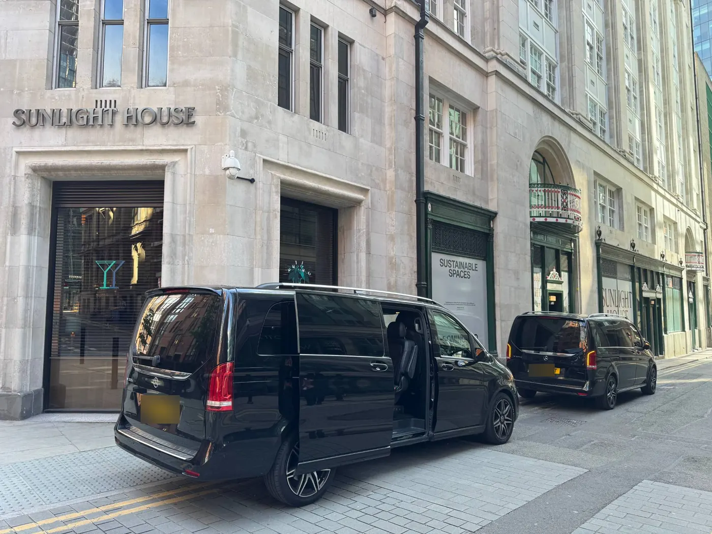 Two Mercedes V-Class chauffeur cars outside Sunlight House in Manchester