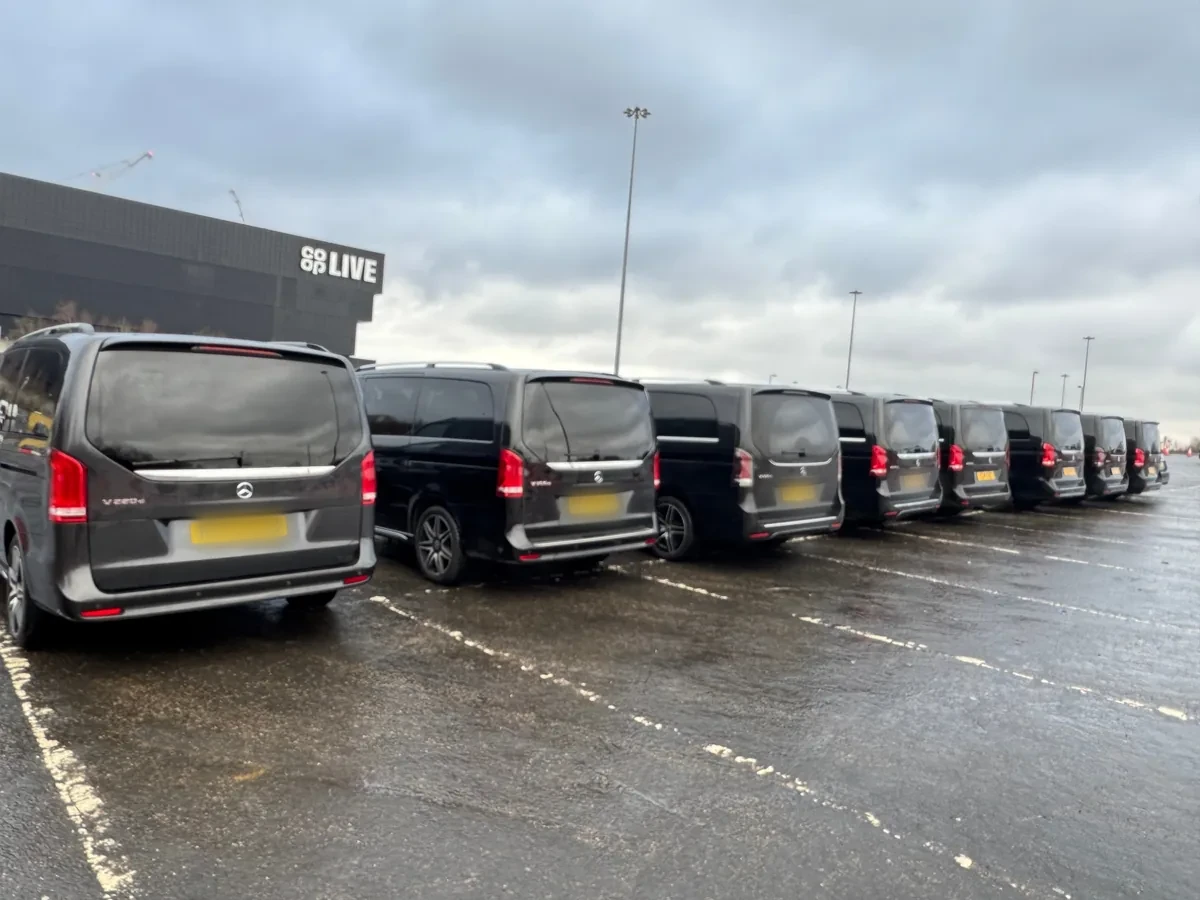 A line of black Mercedes-Benz V-Class chauffeur cars parked beside the Co-op Live arena in Manchester