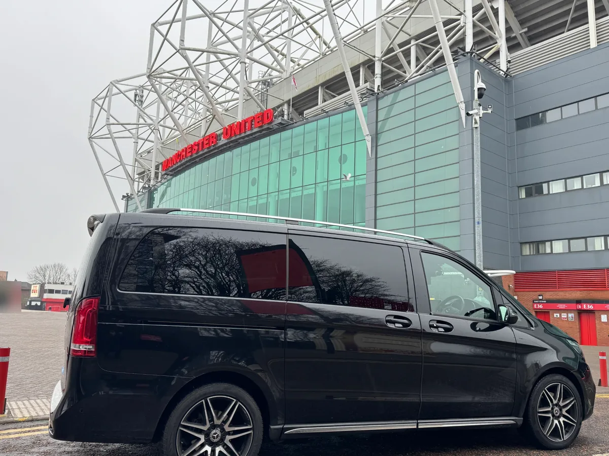 Black Mercedes-Benz V-Class chauffeur car outside the Manchester United sign at Old Trafford