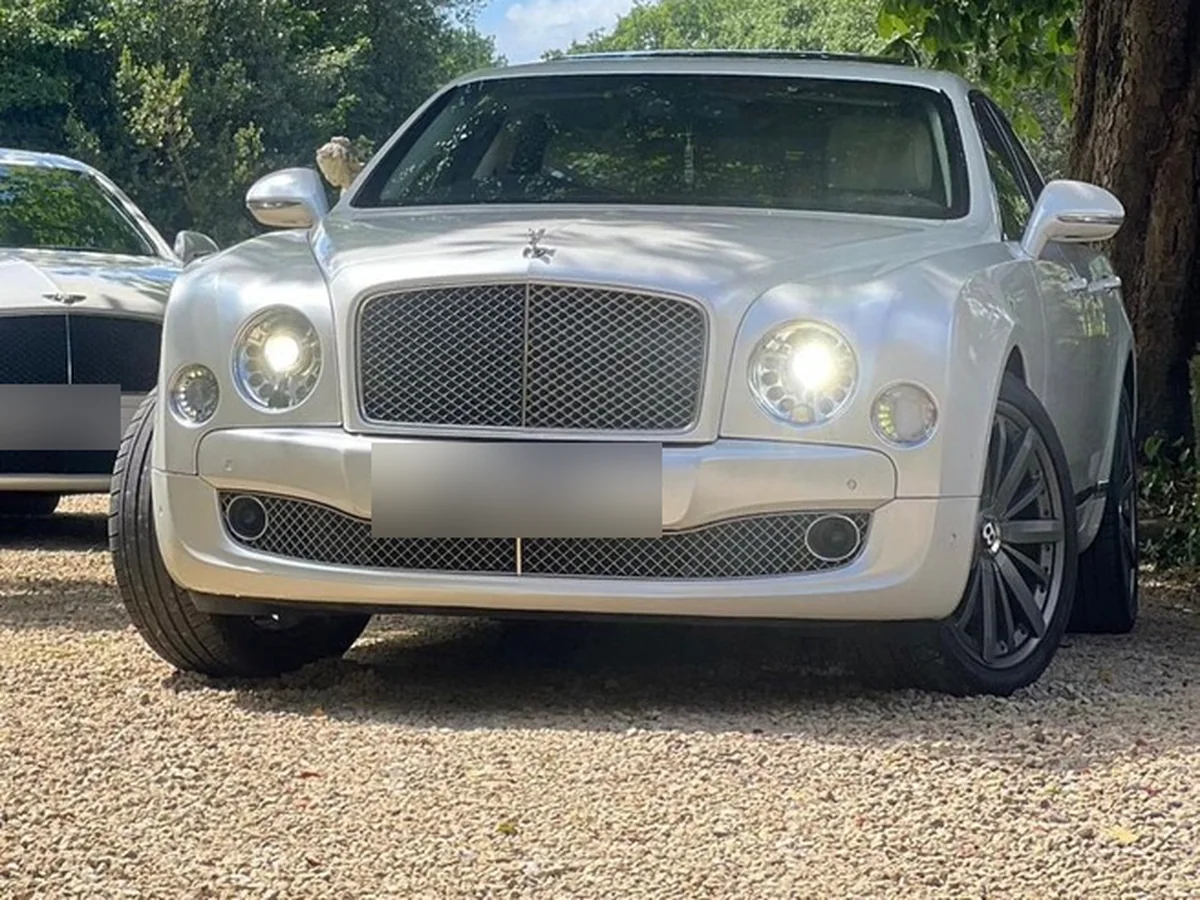 Silver Bentley Mulsanne wedding car parked under a tree on a gravel drive